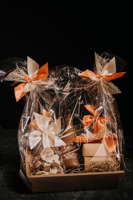 Basket with a chocolate bottle, 3 bags of different products and a box of pralines